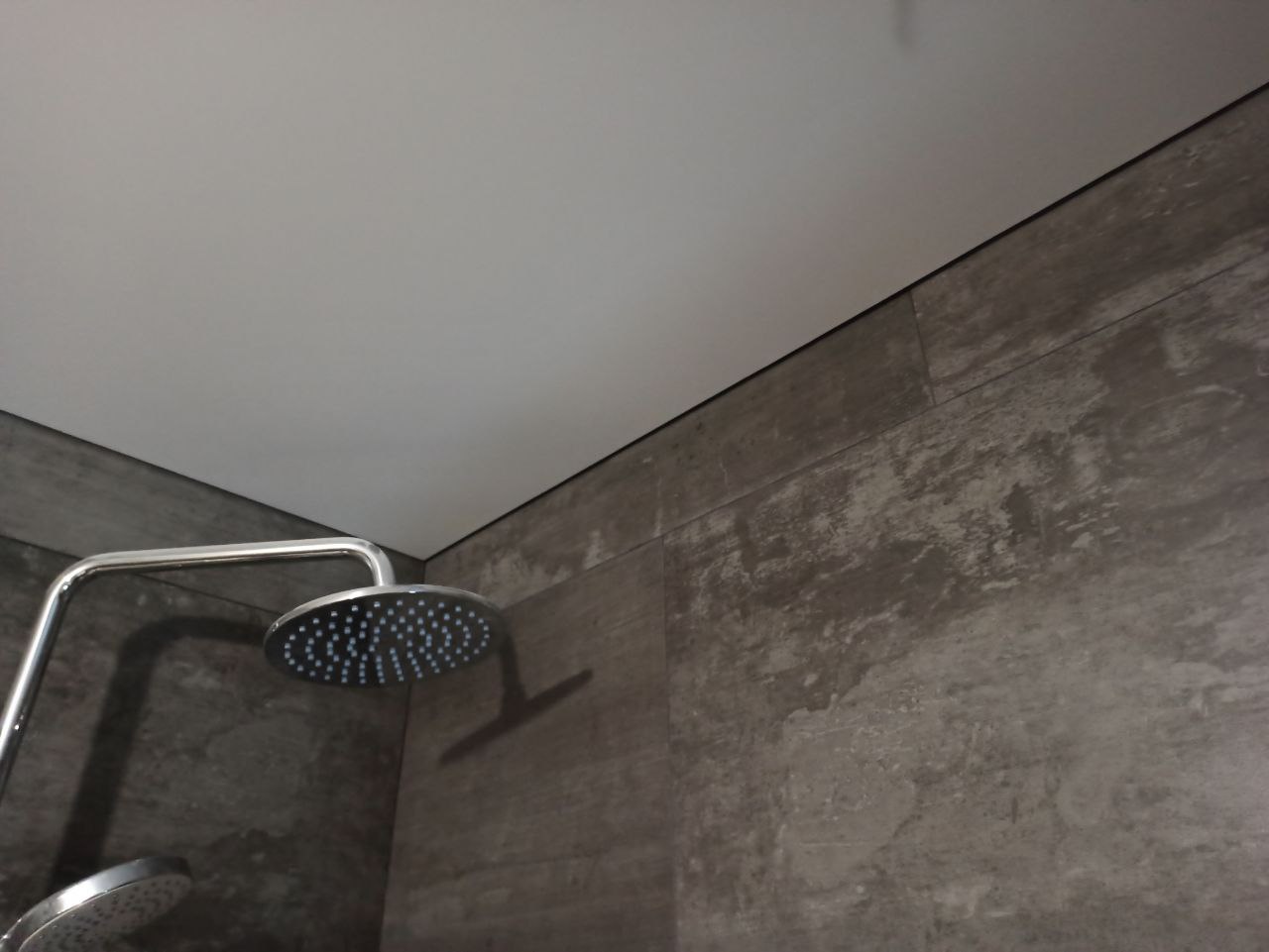 Натяжное полотно не имеет видимого соединения со стеной, и декоративные заглушки (или потолочный плинтус) здесь не используются